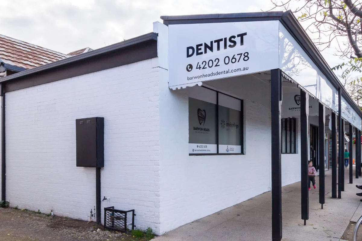 DENTIST sign mounted above the white-rendered shopfront entrance.