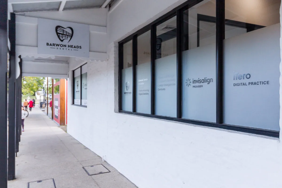 Footpath alongside the clinic showing services etched into the front windows.