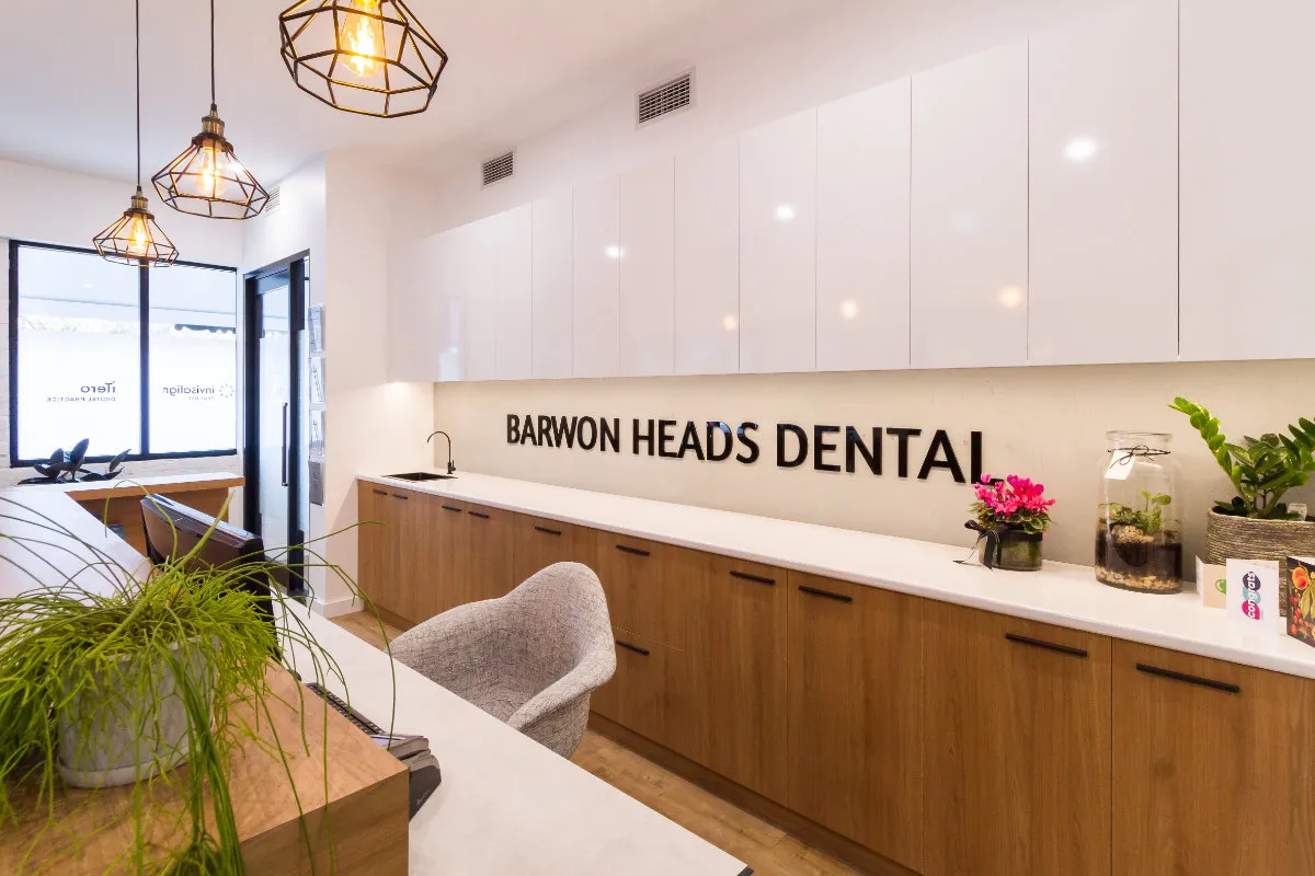 Reception desk and timber-veneered storage with BARWON HEADS DENTAL signage.