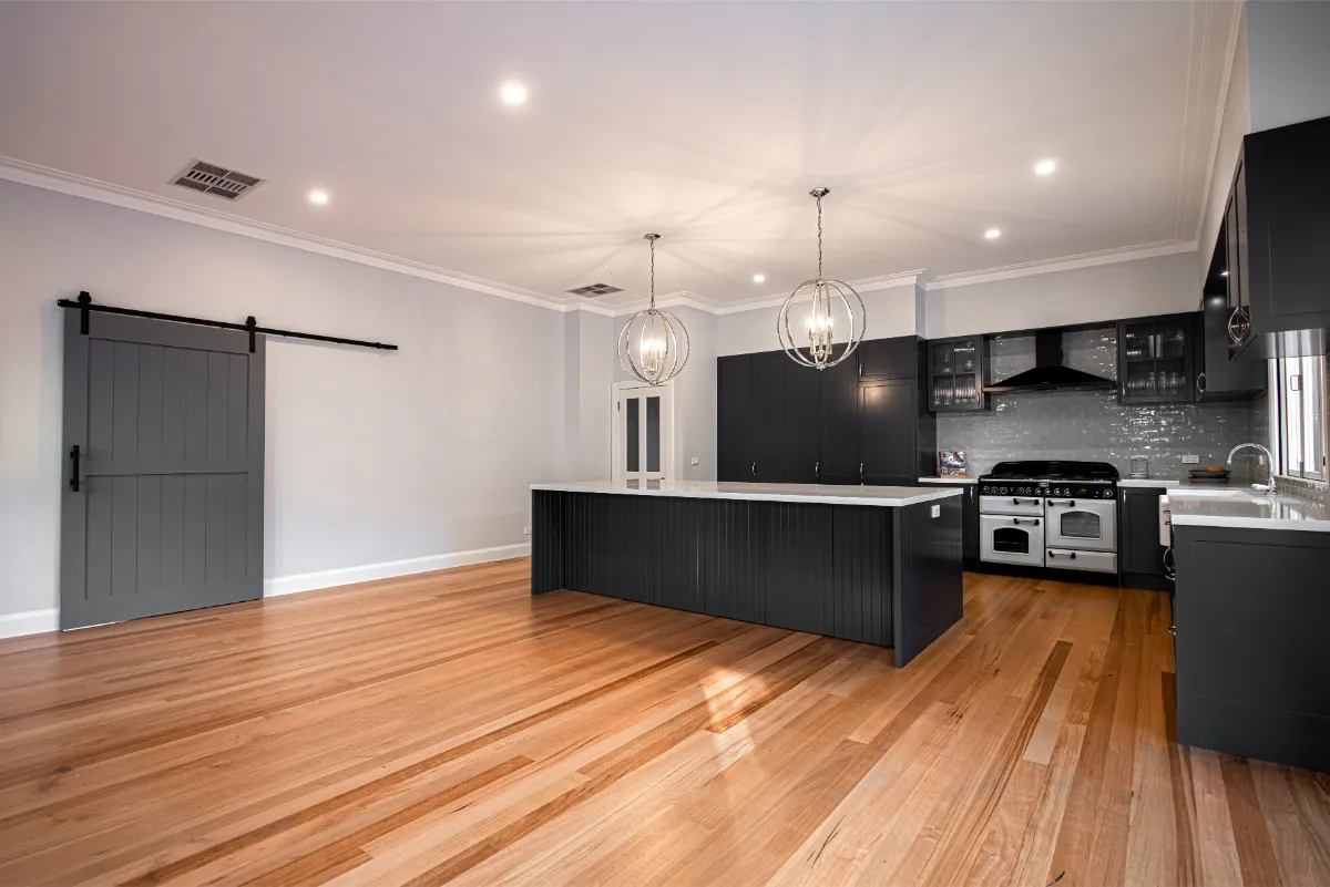 Surrey Hills Hamptons-style kitchen with charcoal Shaker cabinets, white range, and barn-door pantry.